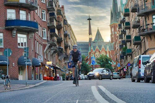 Man in Black Jacket Riding Bicycle on Road