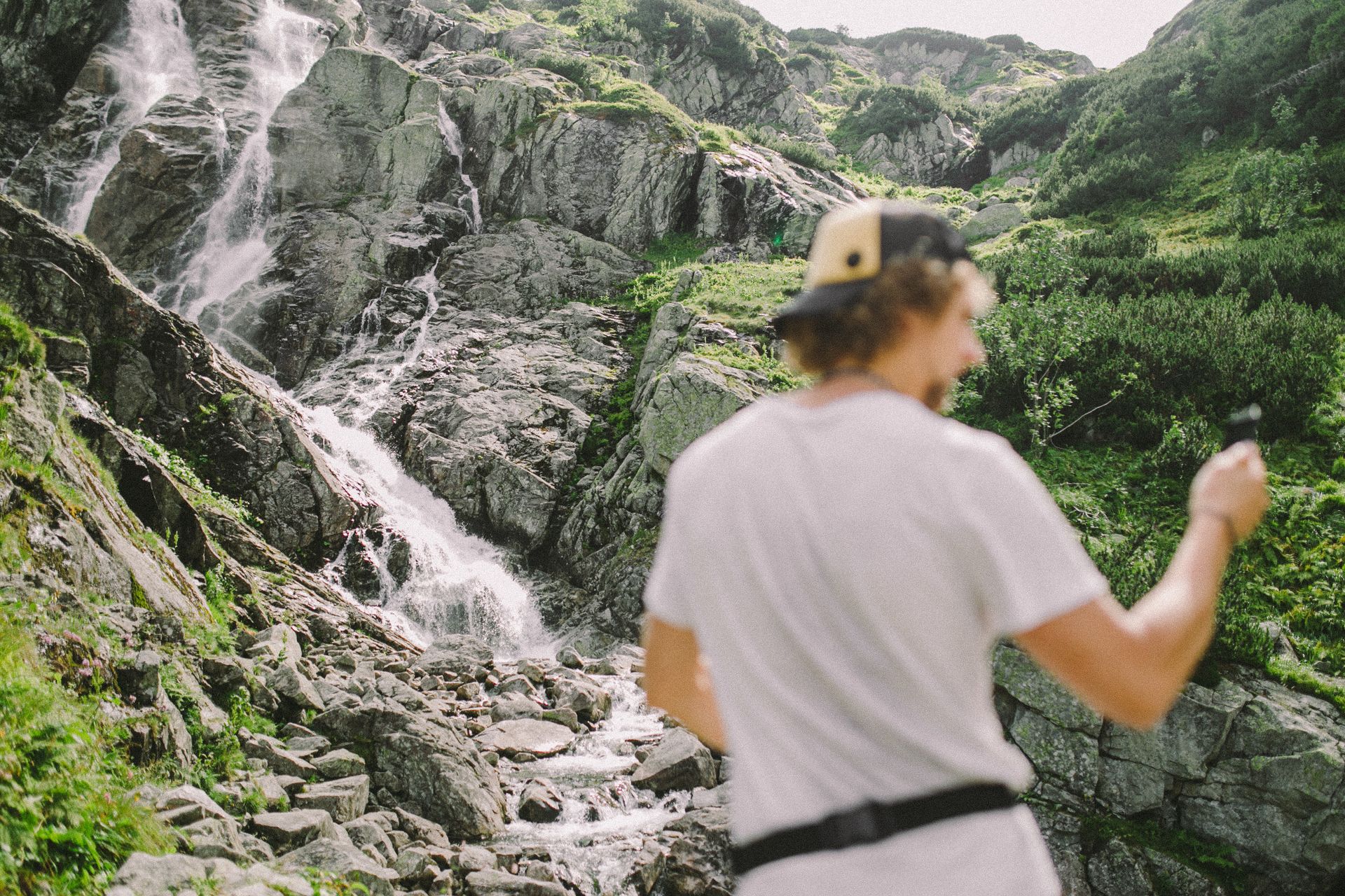 Adventurer captures breathtaking mountain waterfall, ideal for travel inspiration.