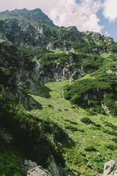 在明亮的蓝天下，探索充满生机的绿色山景