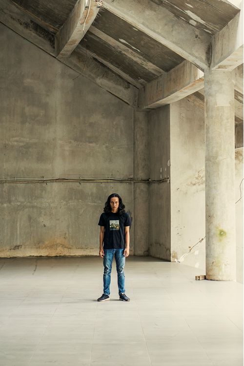 Free Portrait of a man standing in an empty, industrial concrete building interior. Stock Photo