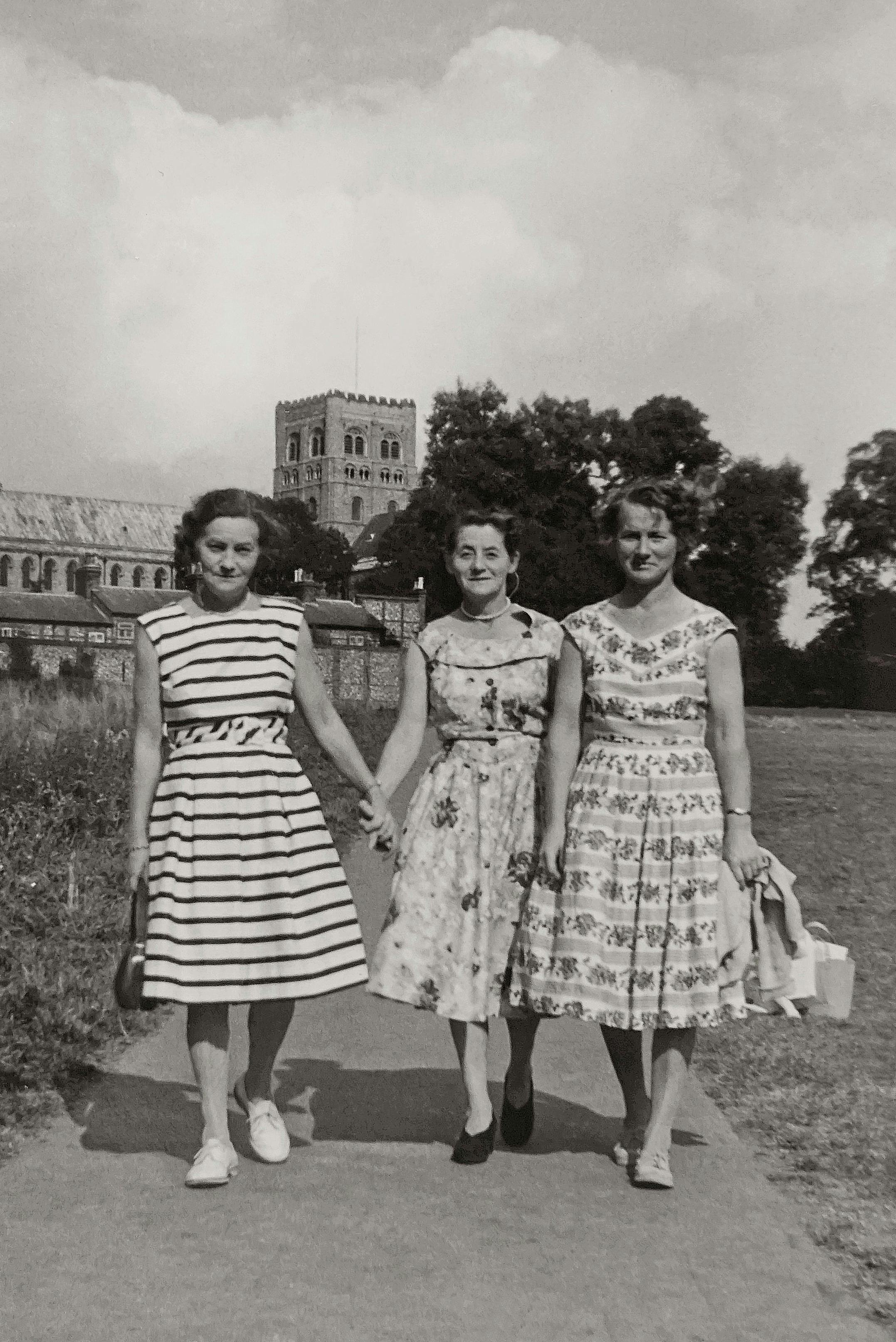 Classic vintage photo of three women walking outdoors in summer fashion.