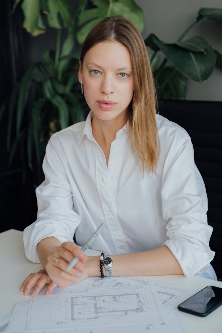 A Woman In White Top Holding A Pen