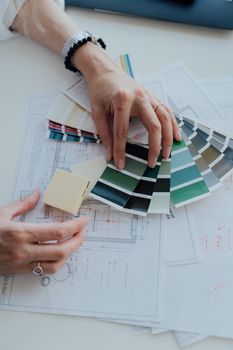 室内设计师在工作空间中评估色彩样本和蓝图