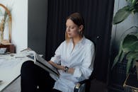 一名女性在办公室阅读杂志，展现了现代工作场所的氛围