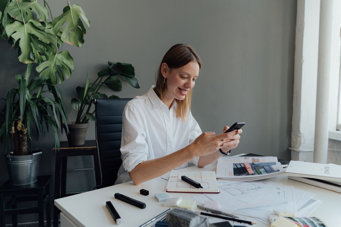 Woman in White Shirt Holding Smartphone