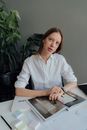 办公室里，一位自信的女性正平静地坐在办公桌前思考工作