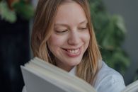Smiling Woman in White Shirt Holding Book