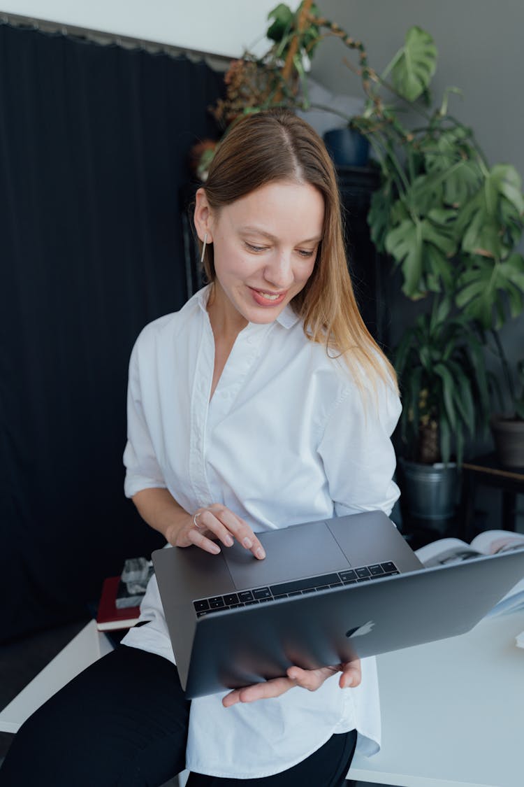 Woman In White Dress Shirt Using A MacBook