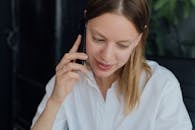 Woman in White Dress Shirt Holding Black Smartphone