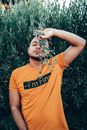 Man in an Orange T-Shirt Holding Green Plant