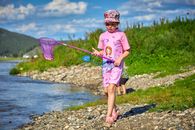 Girl Walking Along the Lakeshore with a Net on a Stick 