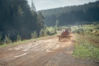 Man Driving Tractor on Dirt Road