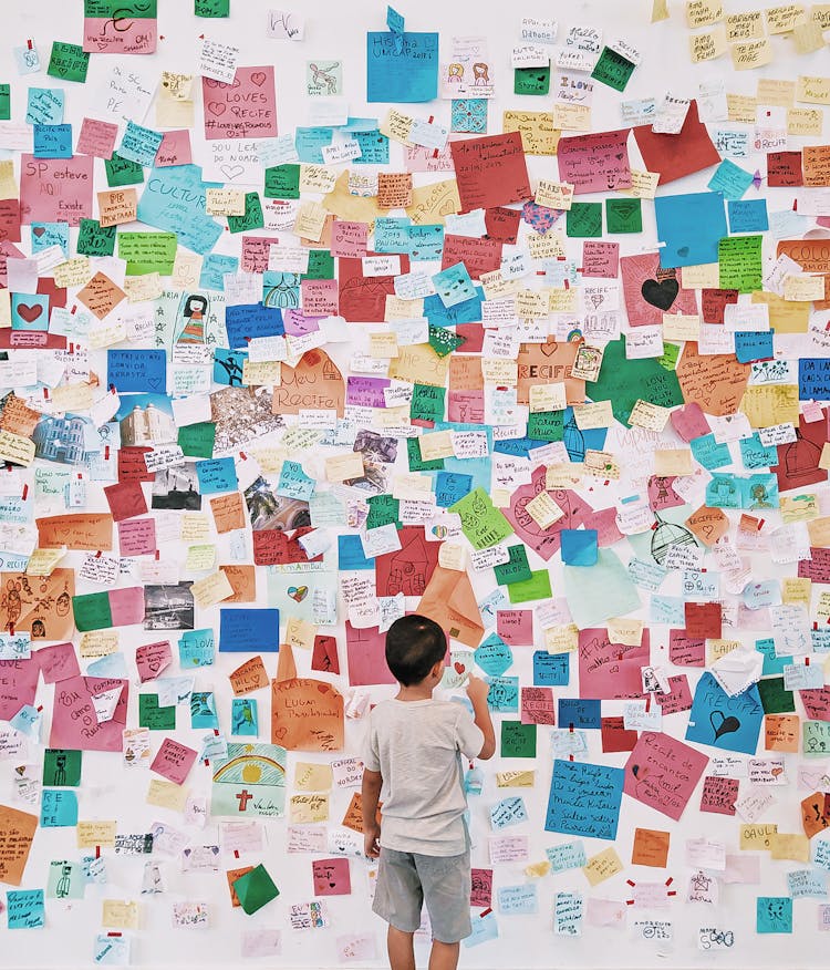 Child Looking At Wall With Memo Card Stickers 