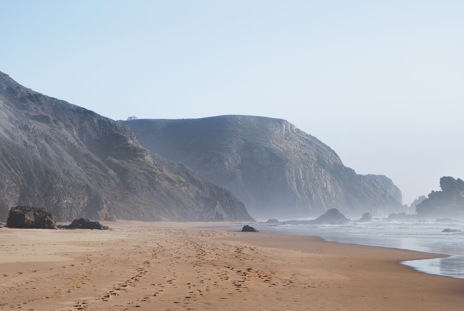 A serene view of the beach houses at <span class="notranslate"><em>Cova do Vapor</em></span> against the rising sun.