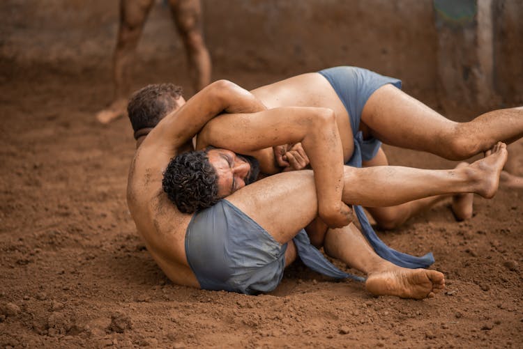 Men Wrestling On Dirt