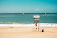 在晴朗的天空下，人们欣赏着法国圣让德鲁斯风景秀丽的海滩