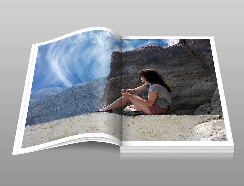 免费 坐在白天的岩石的棕色地层的灰色衬衫的女人 素材图片