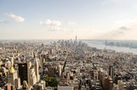 在晴朗的天空下，纽约市的鸟瞰图令人叹为观止，展示了河上的标志性天际线