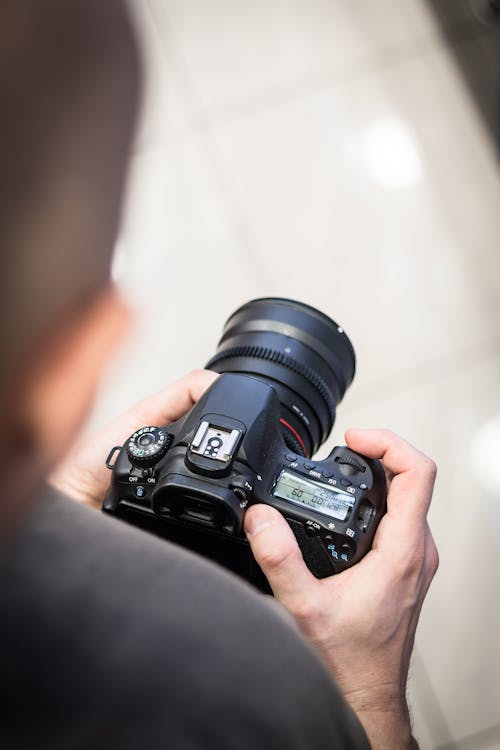 Free Person Holding Dslr Camera in Shallow Photo Stock Photo