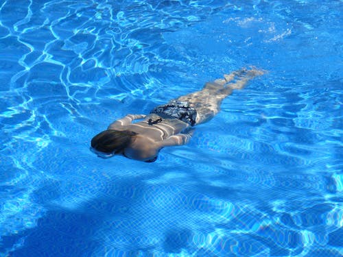 무료 수영장에서 수영하는 여자 스톡 사진