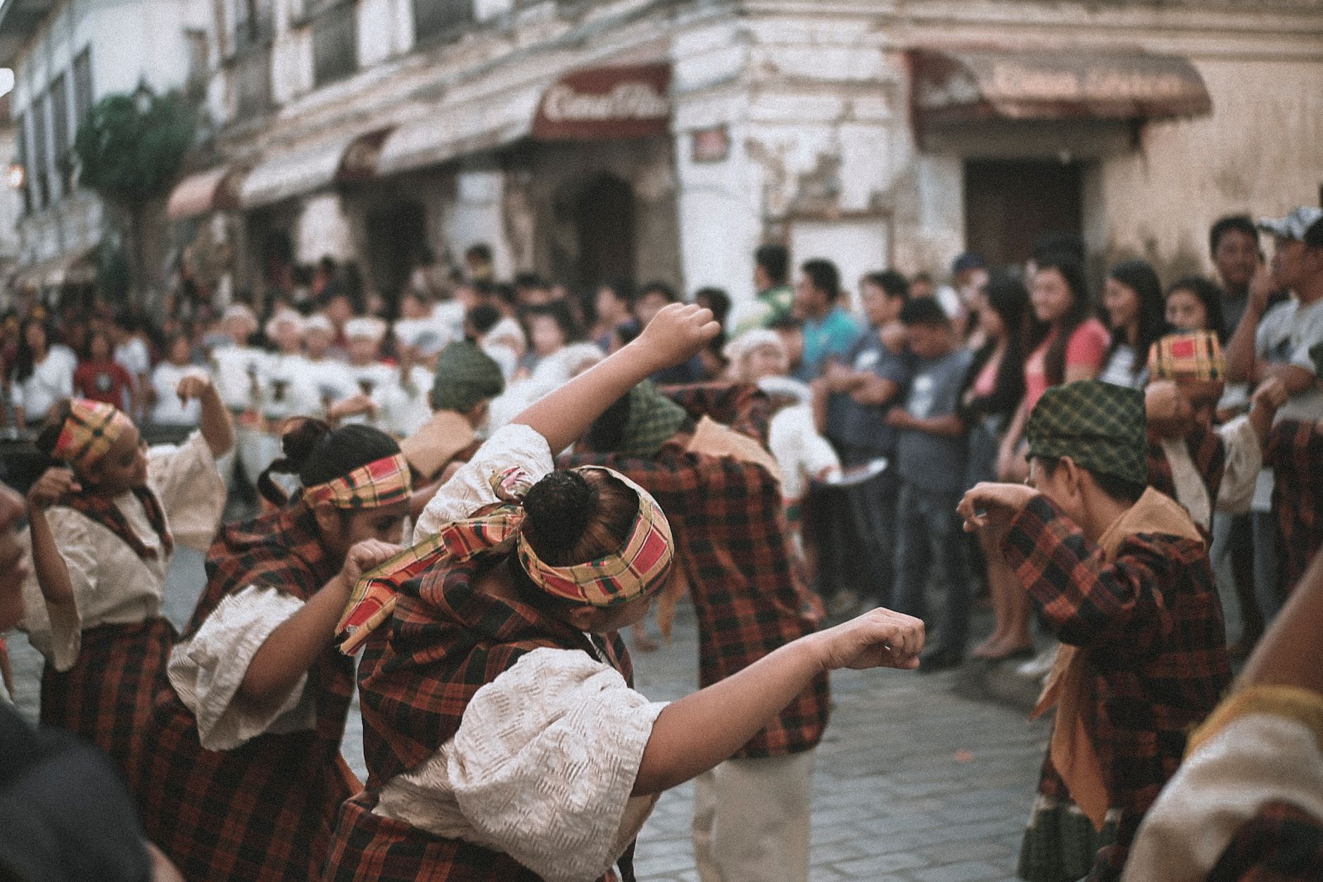Vibrant street festival showcasing traditional dancers in cultural attire, captivating a diverse crowd.