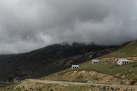 White and Black House on Green Grass Field Near Mountain Under White Clouds