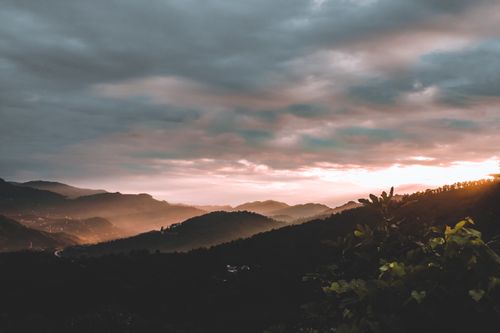 Free Beautiful mountain landscape with fog and sunset hues, capturing the serene beauty of nature. Stock Photo