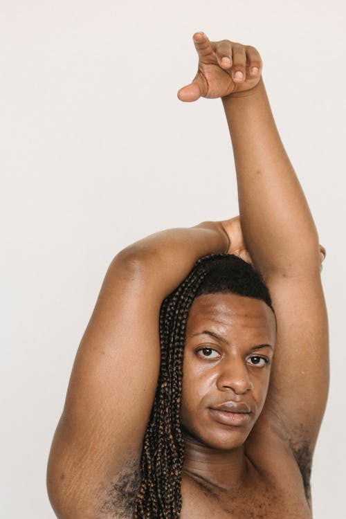Serious feminine black man wit raised arm