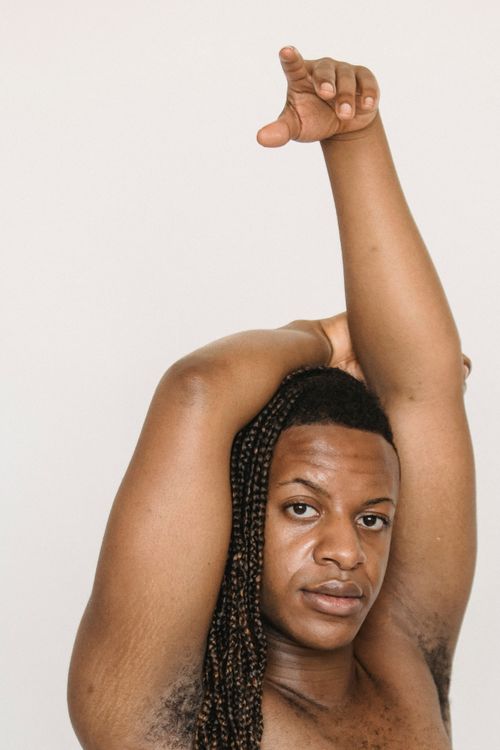 Free Confident African American male with Afro braids keeping arm on head while looking at camera against white background in studio Stock Photo