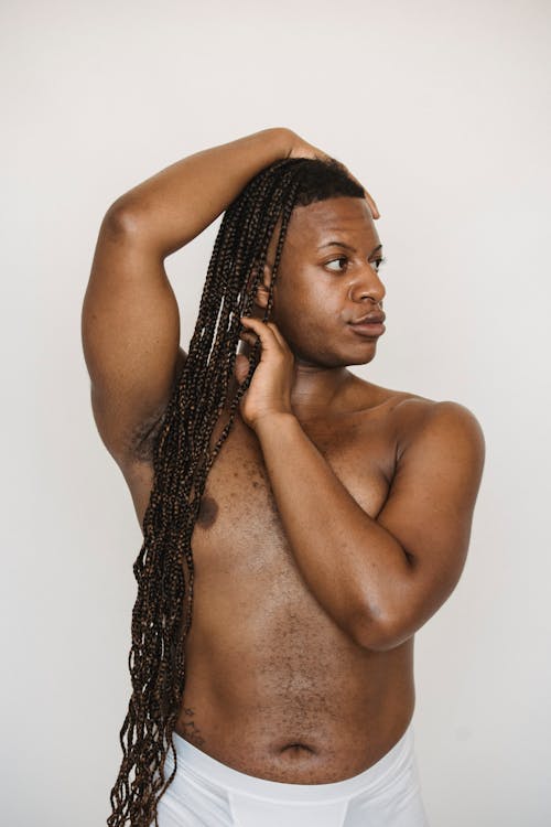 Androgynous shirtless black man with hand on head
