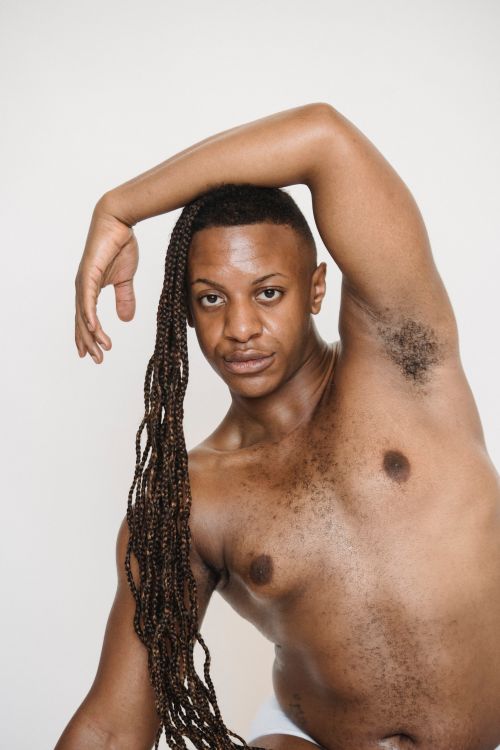 Free Confident plump African American male with Afro braids and naked torso with arm on head looking at camera against white background Stock Photo