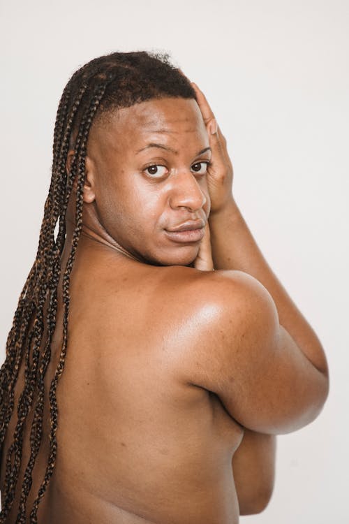 Feminine shirtless black man with looking over shoulder
