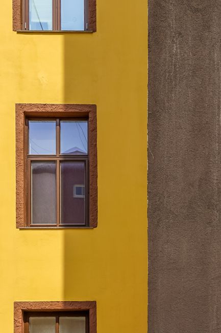 Close-up of vibrant yellow and brown building facade showcasing urban architectural design.