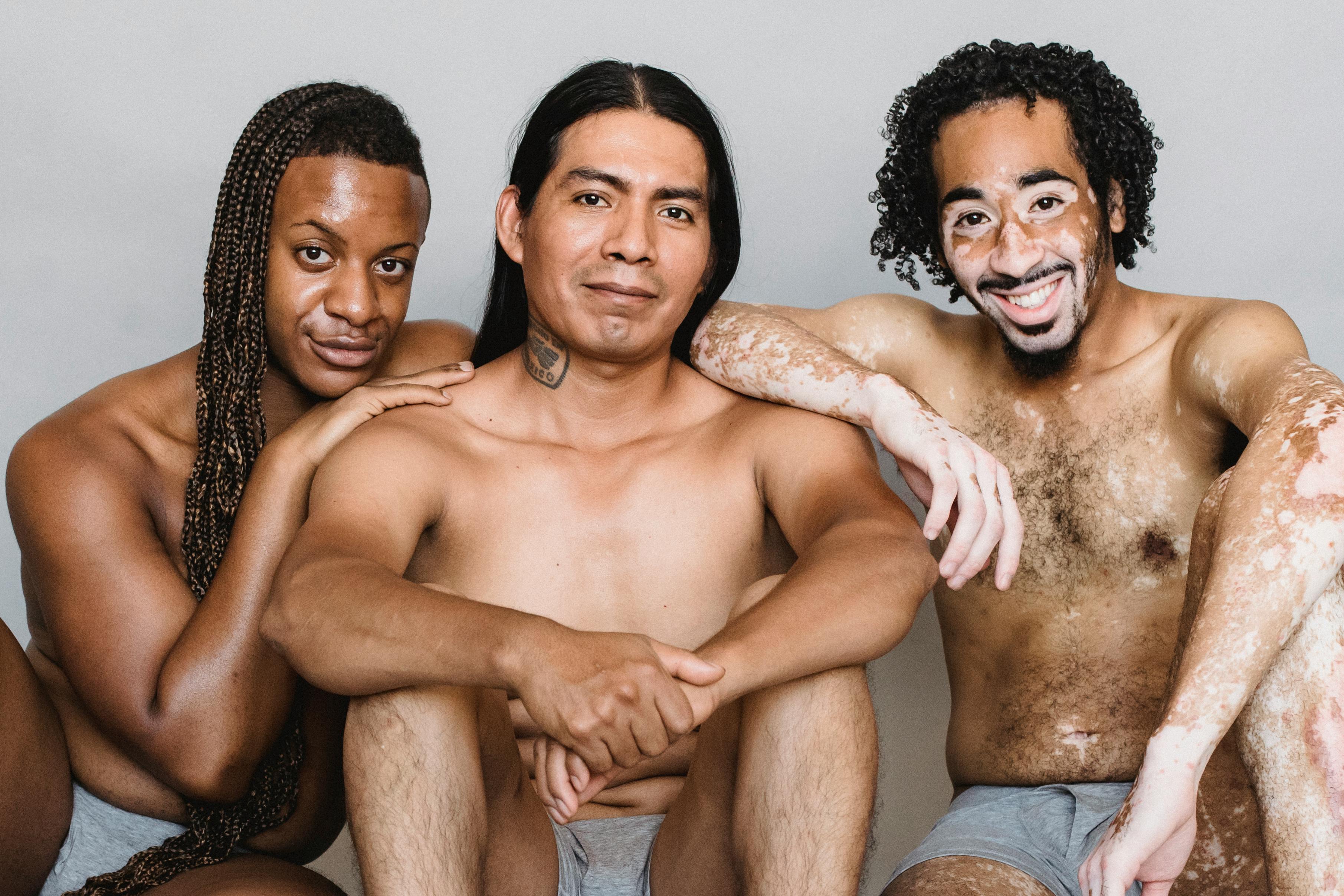 Sosyal bir ortamda özgüveni ve tarzıyla dikkat çeken, arkadaş grubu içinde odak noktası olan karizmatik ve havalı bir gencin gülümserken çekilmiş fotoğrafı.