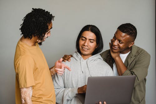 Compañeros De Trabajo Multiétnicos Usando Laptop Mientras Discutían Trabajo Juntos