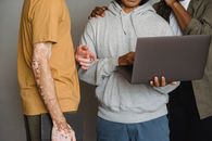 Multiethnic colleagues using laptop while having teamwork