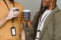 Smiling black man with braids having coffee with friend