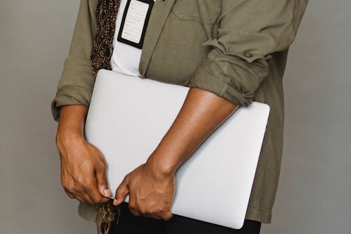 Free Portrait of confident professional holding laptop. Emphasizes modern digital work. Stock Photo
