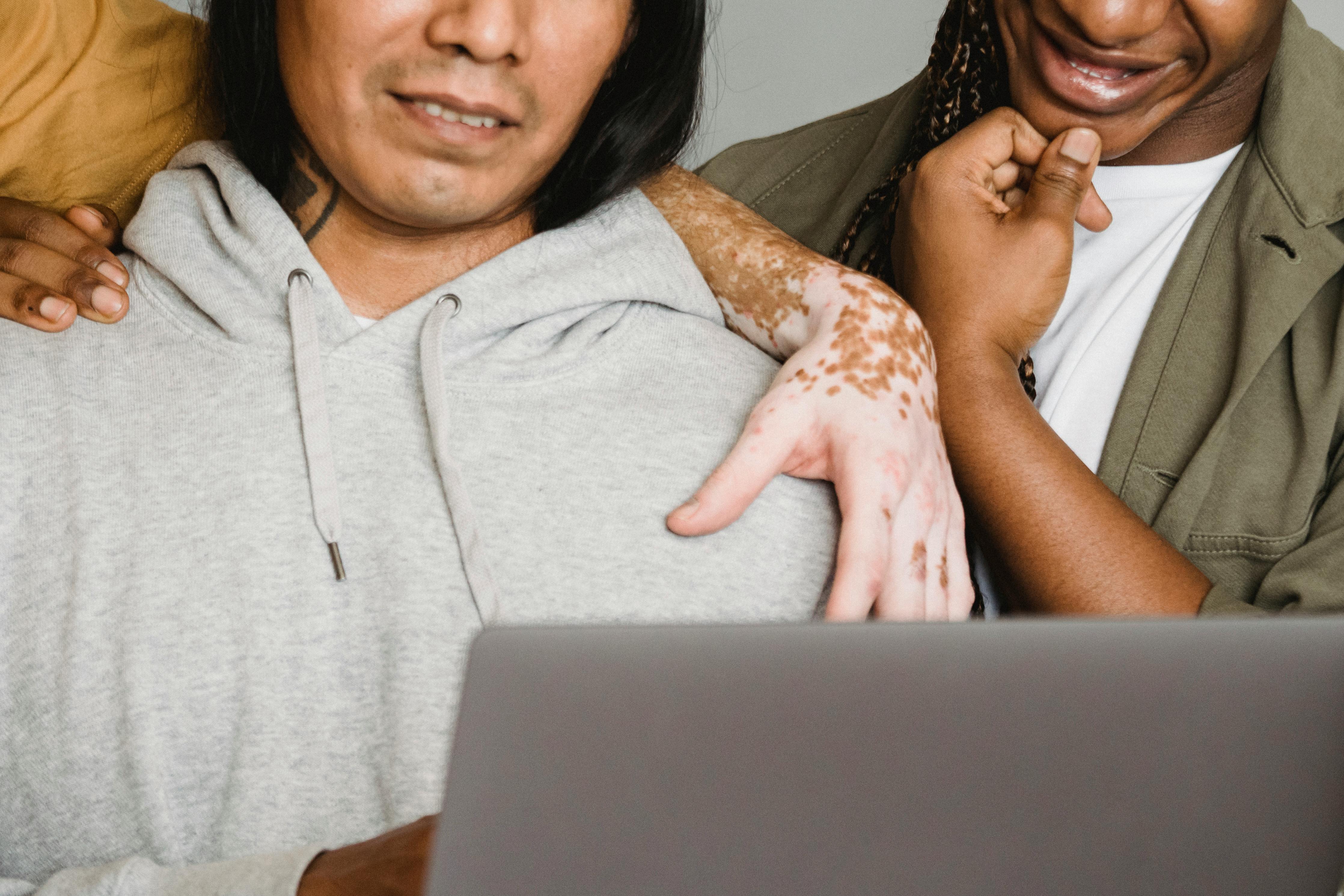 crop diverse coworkers working on laptop