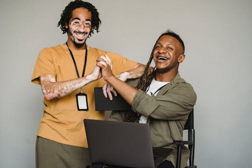 Free Smiling black coworkers holding hands in studio Stock Photo