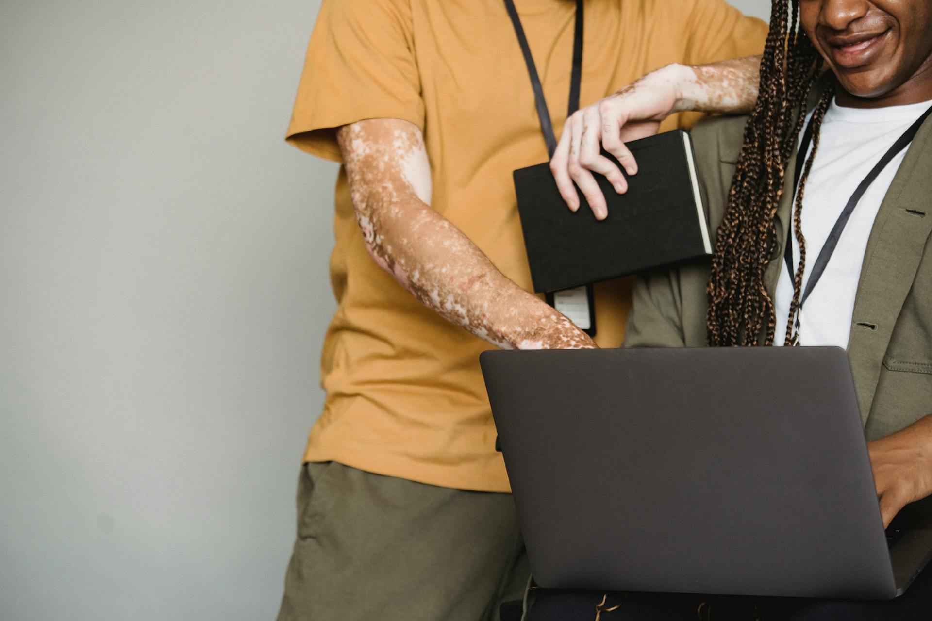 Crop black colleagues browsing laptop