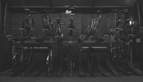 A collection of bicycles parked in a multi-tier rack against a brick wall.