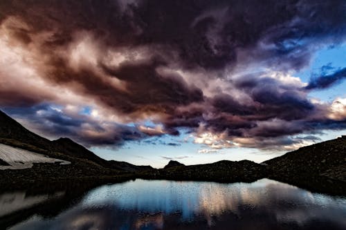 무료 어두운 흐린 하늘 아래 섬의 실루엣 스톡 사진