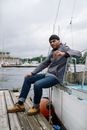 Man in Blue Denim Jeans Sitting on Boat