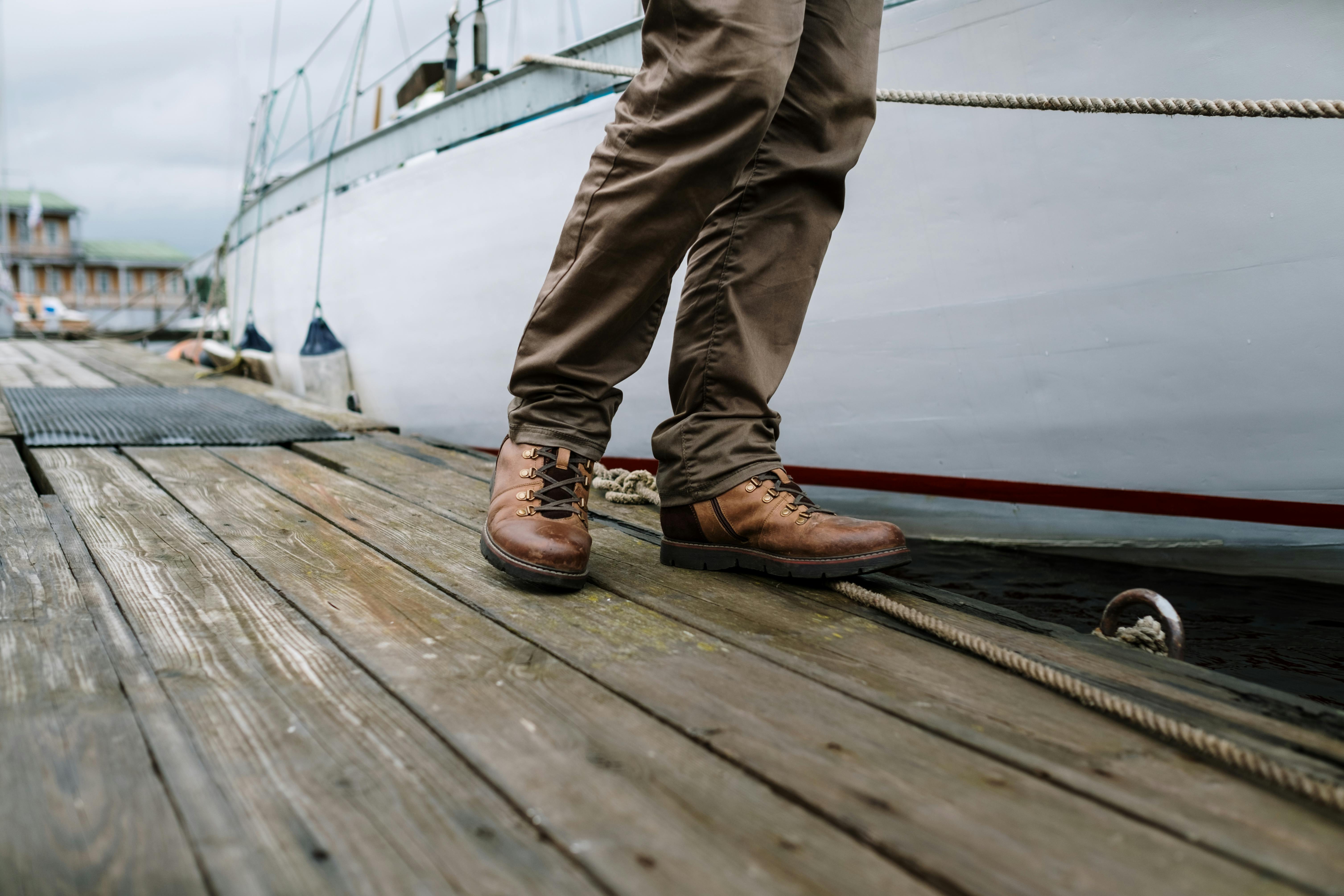A person with black and white shoes standing on a dock photo  Free Shoe  Image on Unsplash