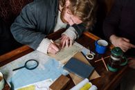 Man in Black Jacket Writing on White Paper