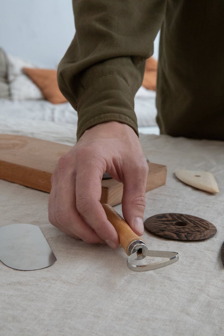 Crop Man With Carving Tool On Table