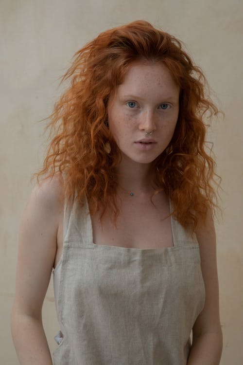 Gentle woman with red head and freckles on skin