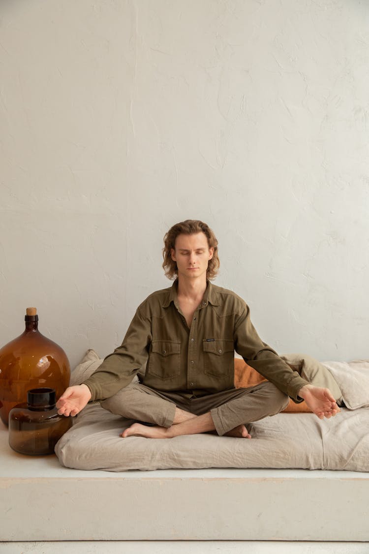 Mindful Man With Crossed Legs Practicing Yoga At Home