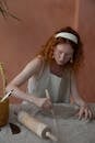 Focused woman cutting clay slab in pottery